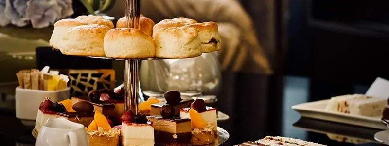 Desserts and bread on a stand on a table