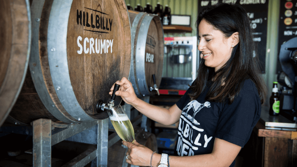 woman pouring cider from barrel