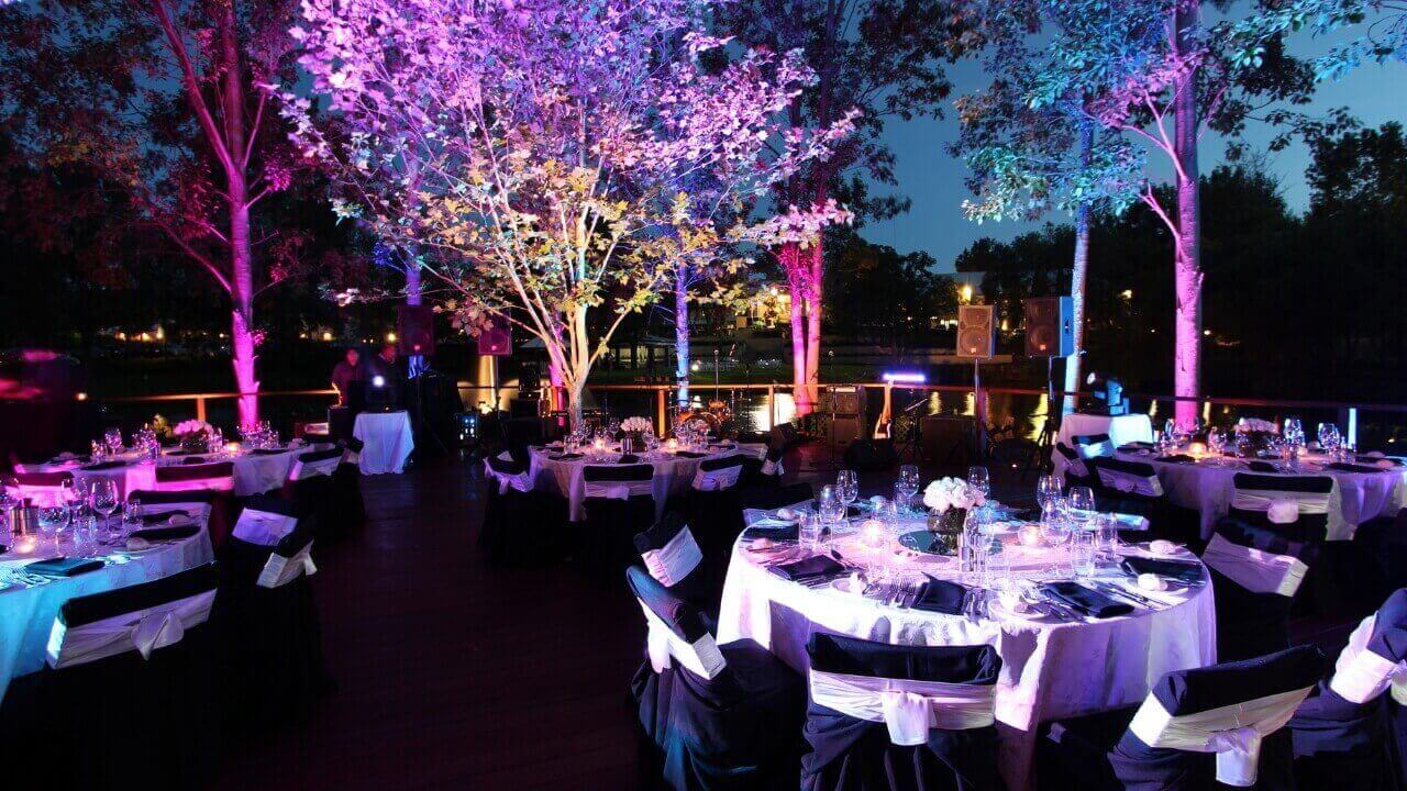 Wedding tables outdoors under colourful lights